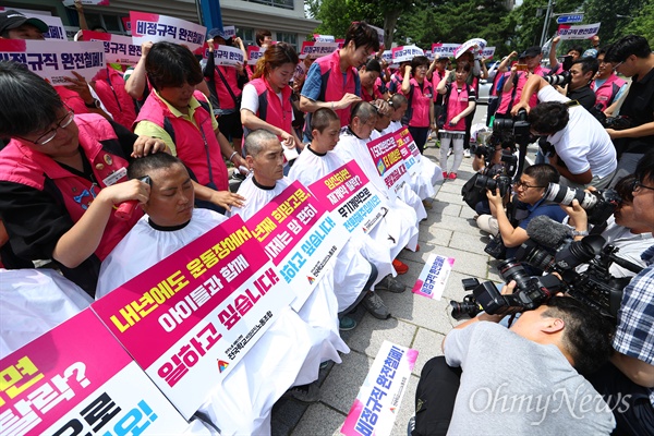  전국학교 비정규직 노동조합 조합원들이 12일 오후 서울 종로구 국가일자리위원회 앞에서 기자회견을 열고 스포츠강사 무기계약전환을 촉구 집단 삭발을 하고 있다. 