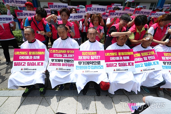  전국학교 비정규직 노동조합 조합원들이 12일 오후 서울 종로구 국가일자리위원회 앞에서 기자회견을 열고 스포츠강사 무기계약전환을 촉구 집단 삭발을 하고 있다. 