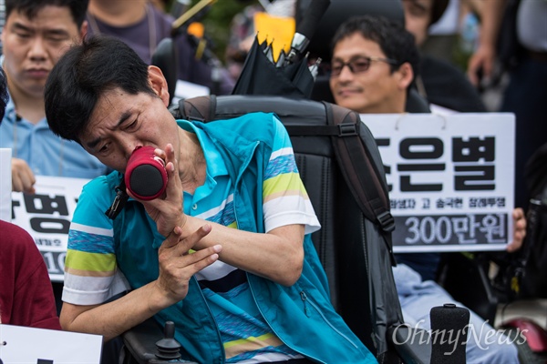  벌금 90만원에 대한 자진노역을 신청한 장애인인권활동가 이경호씨가 17일 오후 서울 서초구 서울중앙지방법원 정문 앞에서 장애인인권 활동가 박옥순,이경호,이형숙 벌금탄압 규탄 및 자진노역 기자회견에 참석해 물을 마시고 있다. 