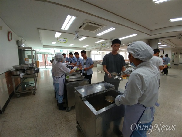 급식조리원들이 학생들에게 음식을 나눠주고 있다.