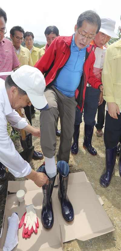 자유한국당 홍준표 대표가 지난 7월 19일 오후 청주시 상당구 낭성면 수해 지역을 찾아 장화를 신고 있다. 