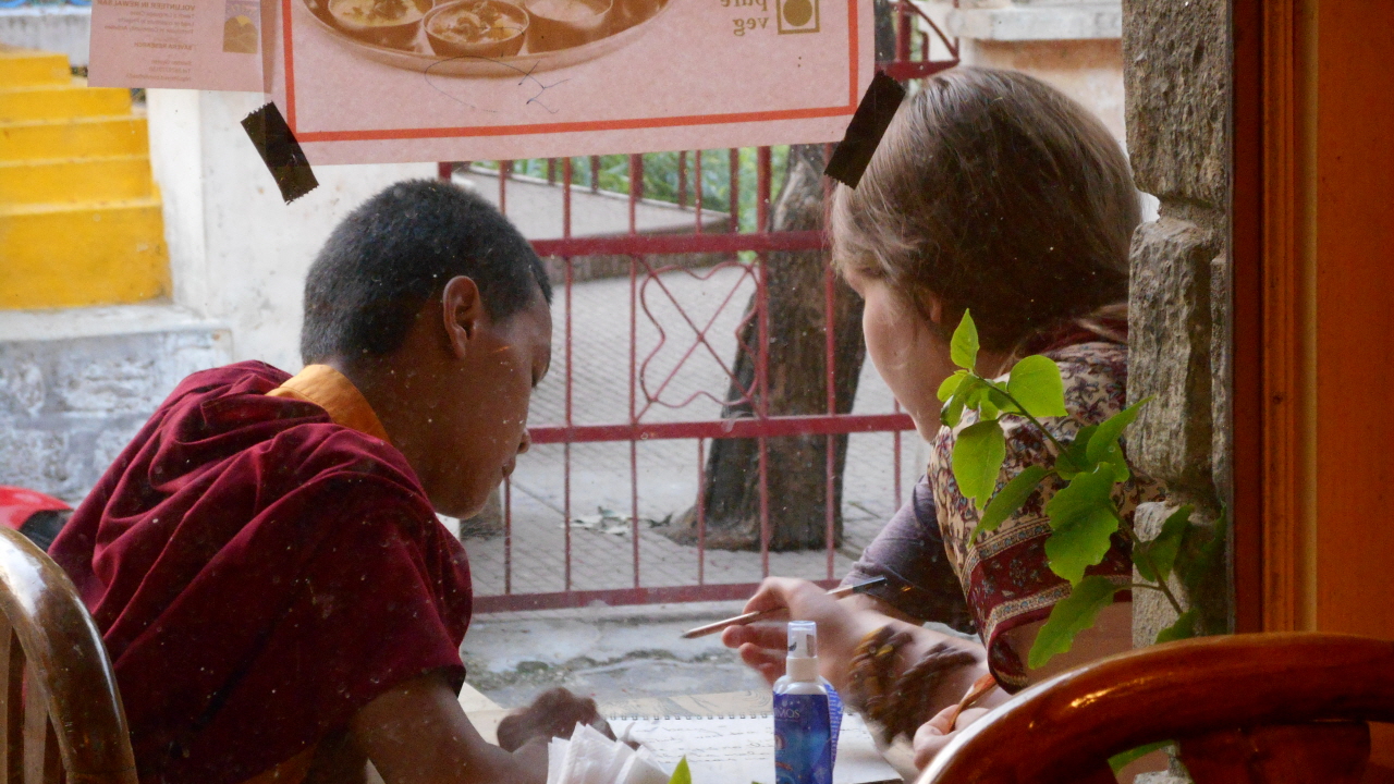 식당 앞에서 짝사랑하는 마리아와 뭔가 얘기를 나누고 있는 티베트 소년 승려.