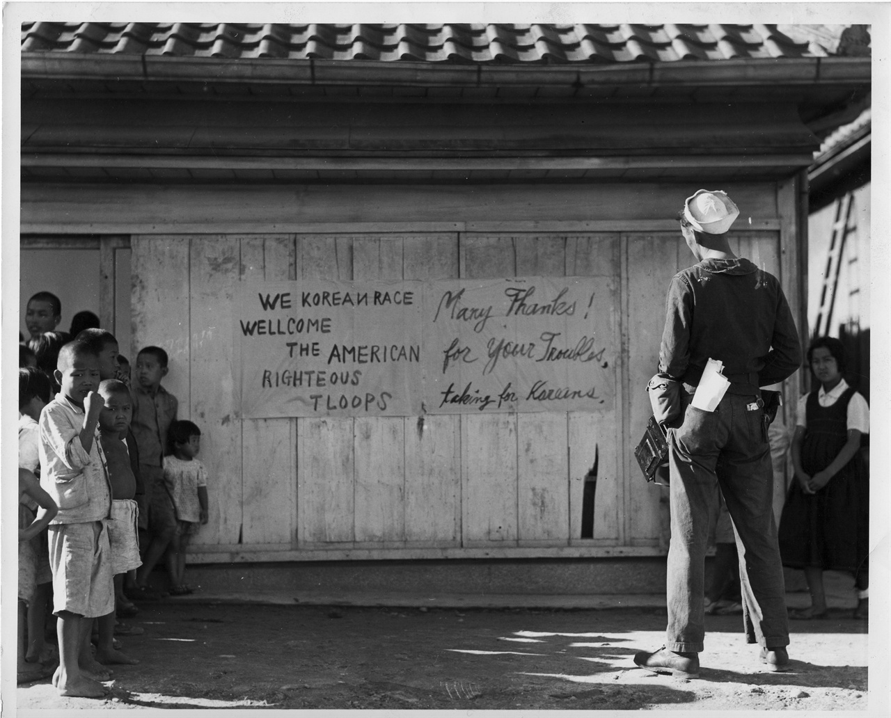  1945. 9. 16. 한 미군이 “한국인은 미군을 환영한다”는 게시판을 바라보고 있다. 