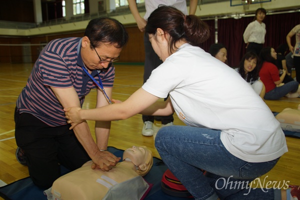 대구상원고 김사철 교장이 강사의 도움을 받아 심폐소생술 실습을 하고 있다.