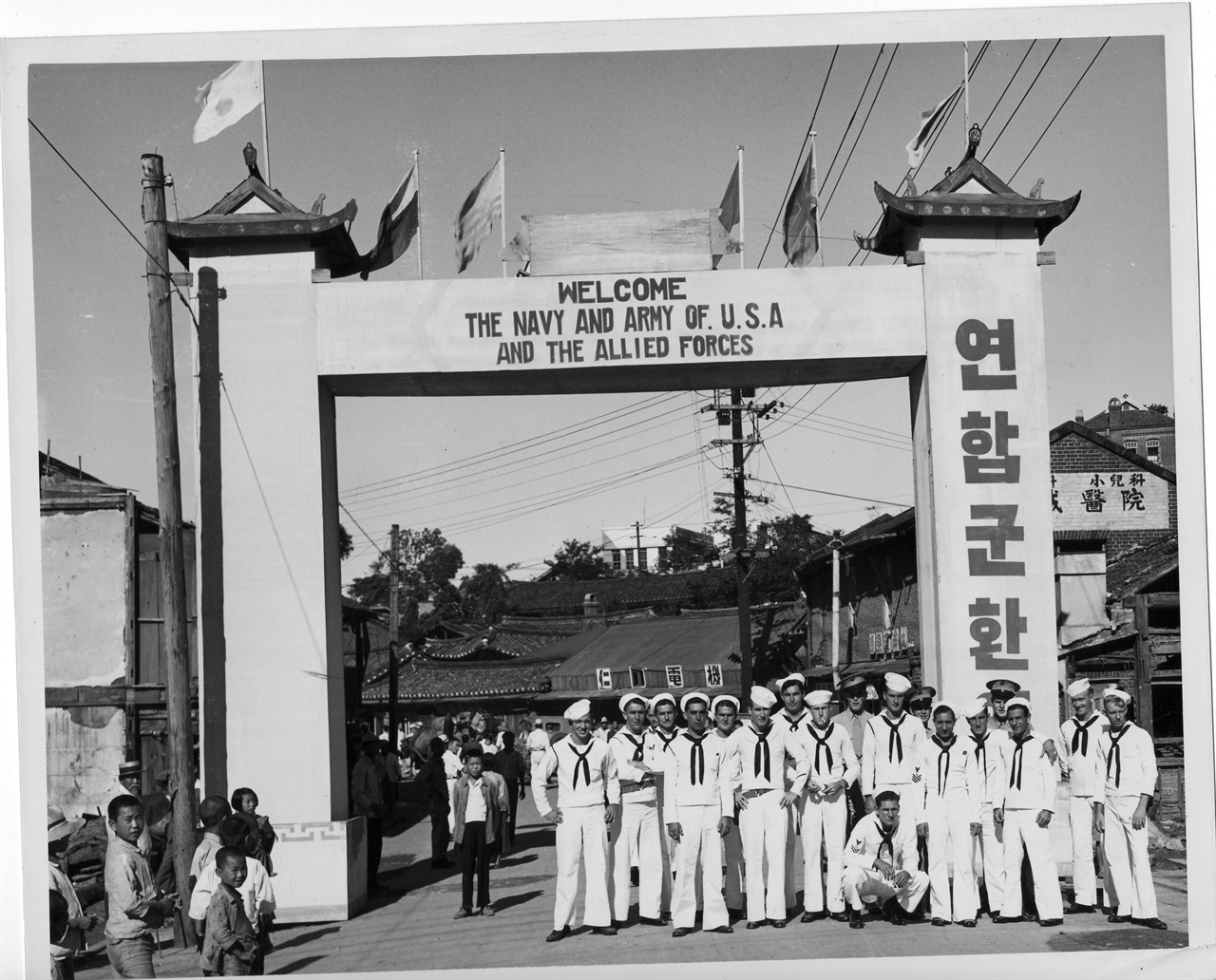  1945. 9. 인천. 연합군 환영아치 앞에서 미 해군들이 기념촬영을 하고 있다.