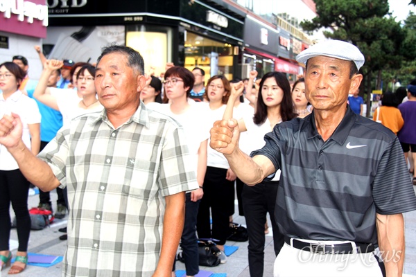 21일 저녁 창원 정우상가 앞에서 열린 '친일잔재 청산과 일제 강제징용 노동자상 건립, 한반도 평화와 자주통일 경남대회'에서 일제 강제징용 노동자의 유족인 정용병(67, 남해), 김수웅(73, 거창)씨가 참가자들과 함께 팔뚝질을 하고 있다.