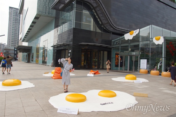 대구시 중구 반월동 현대백화점 앞에 설치된 계란 프라이 앞에서 한 시민이 사진을 찍고 있다.