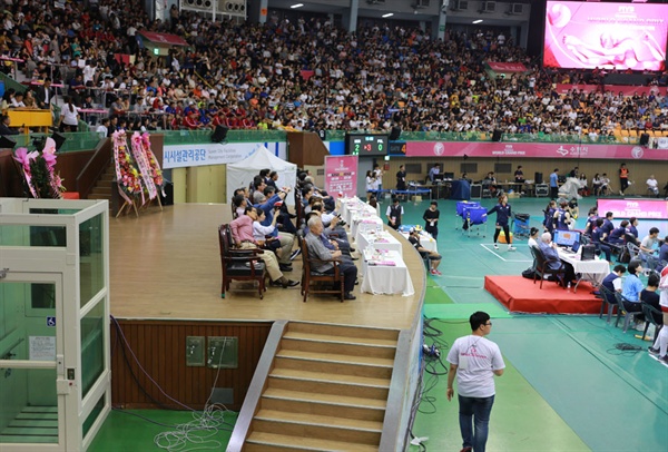 대한배구협회 고위 관계자들이 수원 실내체육관 귀빈석 단상에서 2017 여자배구 월드그랑프리 대회를 관전하고 있다. 반면, 일부 배구 팬들은 자리가 없어 통로와 계단에 서 있거나 주저앉아 관람하기도 했다.
