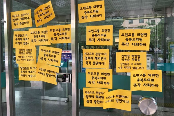  24일 충북지역 시민사회단체는 해외연수를 떠난 도의원의 사퇴를 촉구하는 내용이 담긴 쪽자보를 도의회 현관에 부착했다.(사진 충북참여연대)