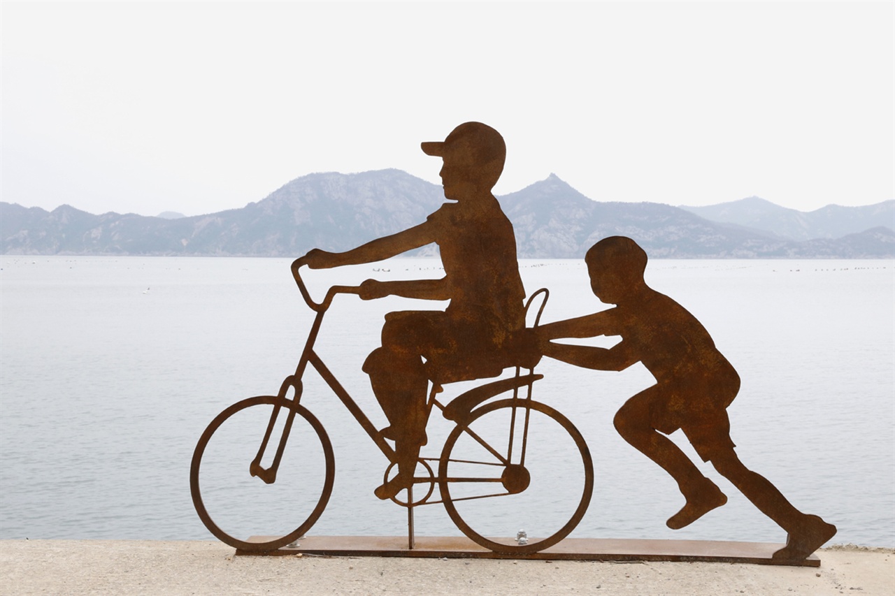 자전거를 타는 아이. '예술의 섬' 고흥 연홍도 바닷가에 설치된 미술작품이다. 배경으로 보이는 섬이 완도 금당도 병풍바위다.