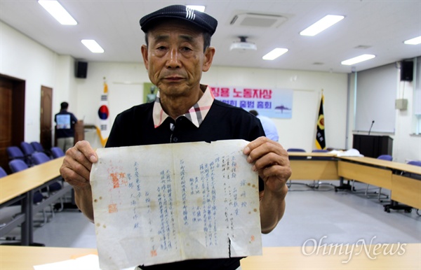  일제 강제징용 노동자(김규철)의 후손인 김수웅(73)씨가 25일 오전 경남도의회 대회의실에서 열린 '일제 강제징용 노동자상 경남건립추진위원회 결성 총회'에 참석해 아버지의 징용 증거 자료를 들어보이고 있다.