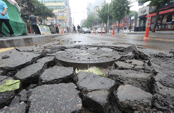서울을 비롯한 수도권 곳곳에 호우경보가 내려진 지난 23일 오전 폭우로 침수됐던 인천 남구 주안역 인근 도로의 맨홀이 역류된 빗물의 힘을 견디지 못해 파손돼 있다. 