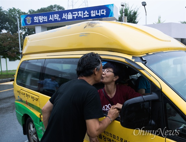 장애인 활동가 박옥순씨가 24일 오후 경기도 의왕시 서울구치소 앞에서 출소 직후 남편을 만나 입맞춤을 하고 있다.