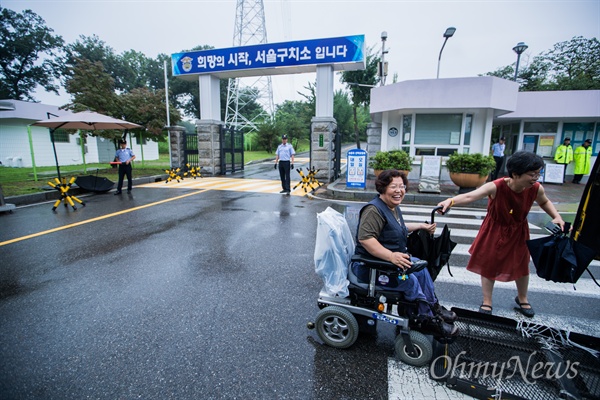 장애인 활동가 이형숙씨가 24일 오후 경기도 의왕시 서울구치소 앞에서 출소 직후 지인들과 인사를 하기 위해 차량리프트에서 내리며 웃고 있다. 
