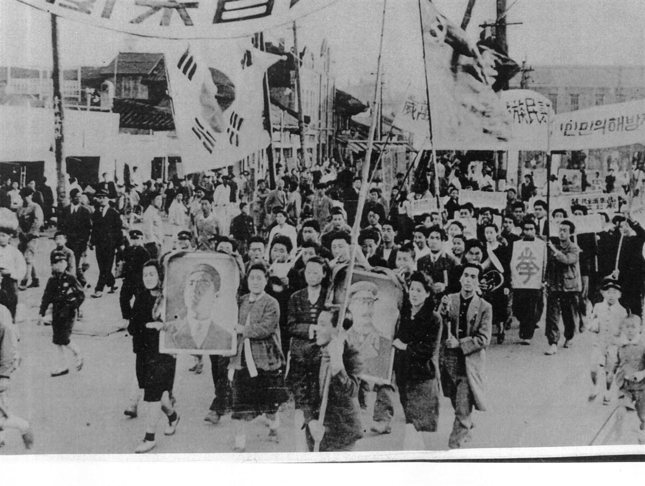  1946. 날짜 미상. 평양. 평양시민들의 김일성과 스탈린 원수에 대한 환영 지지대회 후 시가행진을 하고 있다(북한은 그때까지 태극기를 썼다).