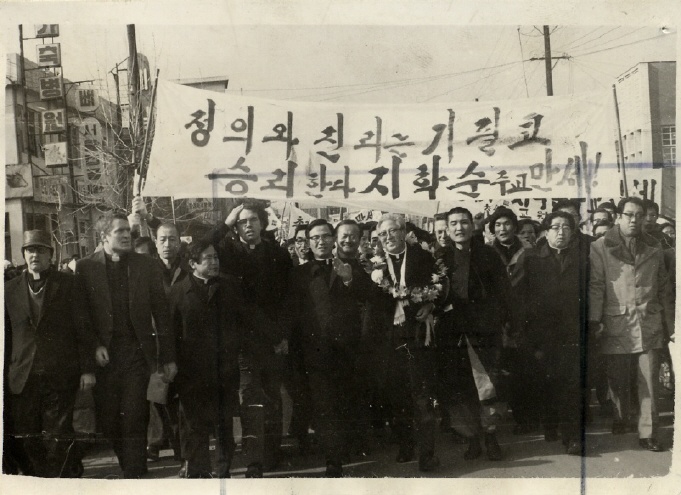  1975년7월20일, 지학순 주교(가운데 꽃다발 쓴 이)와 김지하 시인(지 주교 오른쪽)이 환영인파와 함께 원동성당을 향해 가두행진 중이다.