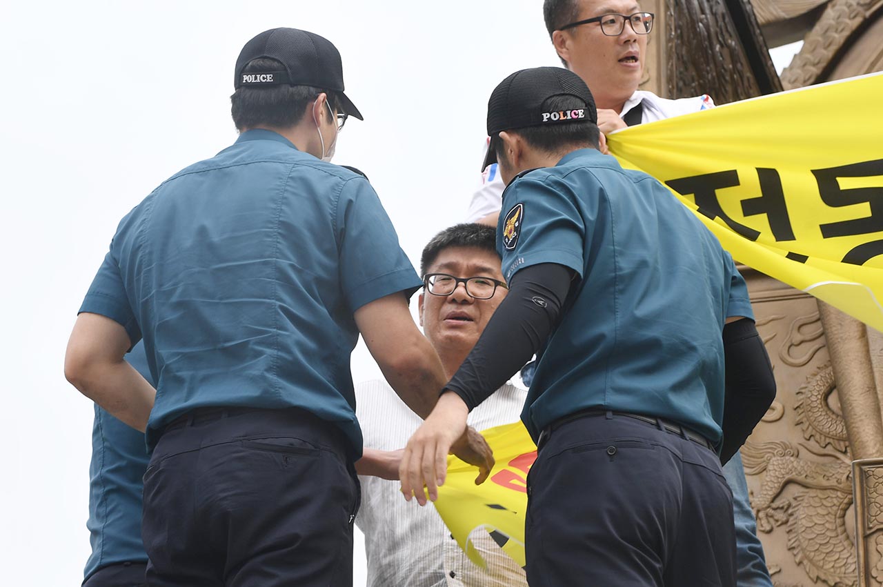 이제 그만 내려가시지요 기아자동차 비정규직 노동자 4명은 27일 오전 10시경 서울 광화문광장내 세종대왕상에 올라가 '현대기아차그룹 정몽구 회장 구속' 등을 외치며 기습시위를 벌이고 있다.