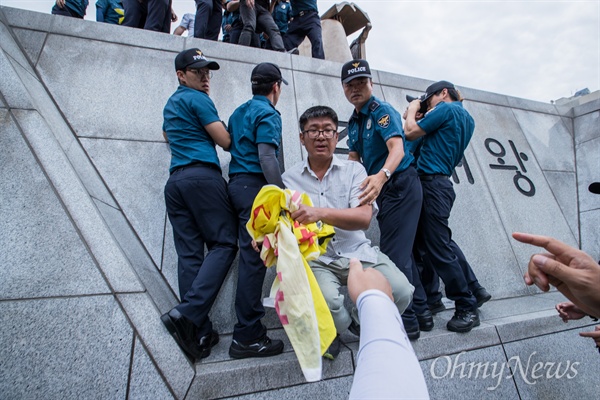  기아자동차 비정규직 노동자들이 27일 오전 서울 광화문광장 세종대왕상에서 정몽구 현대자동차그룹 회장 구속을 촉구하는 기습시위 직후 경찰에게 연행되고 있다.