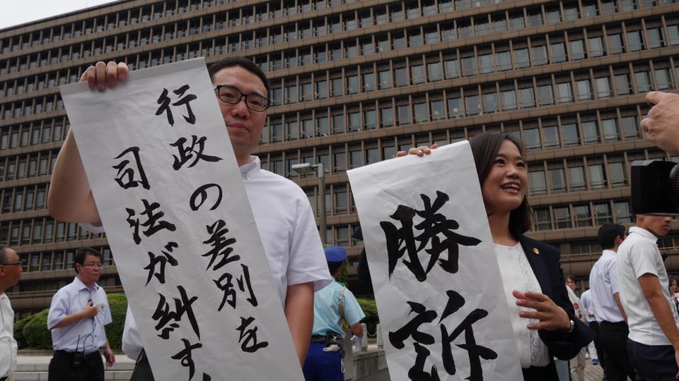 승소 판결 후, 조선학원 측 변호사들이 '승소' '행정부의 차별을 사법부가 바로잡다'라는 종이를 펼치며 결과를 알리고 있다.