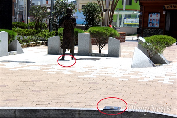 창원 마산회원구 오동동문화거리에 있는 일본군위안부 피해자를 기리는 조형물인 인권자주평화다짐비다. 최근 표지석(아래 원)이 파손되어 치워놓았고, 소녀상 앞에 있던 꽃항아리(위 원)이 없어졌다.