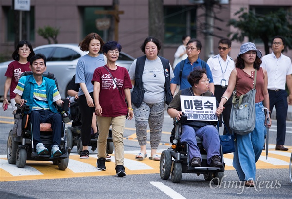 장애인 활동가 박옥순씨가 7월 17일 서울 서초구 서울중앙지방법원 앞에서 자진 노역을 앞두고 기자회견을 마친 동료들과 함께 걷고 있다.