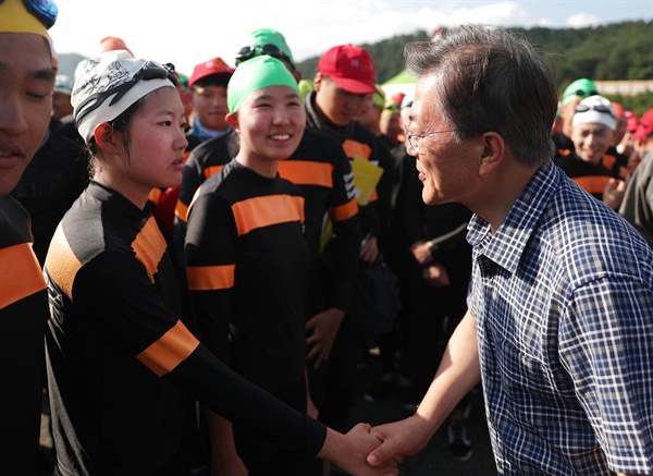 휴가중인 문재인 대통령이 지난 3일 진해 해군사관학교 내 거북선 모형 함을 방문하러 가던 중 만난 해군사관생도들을 만나고 있다.