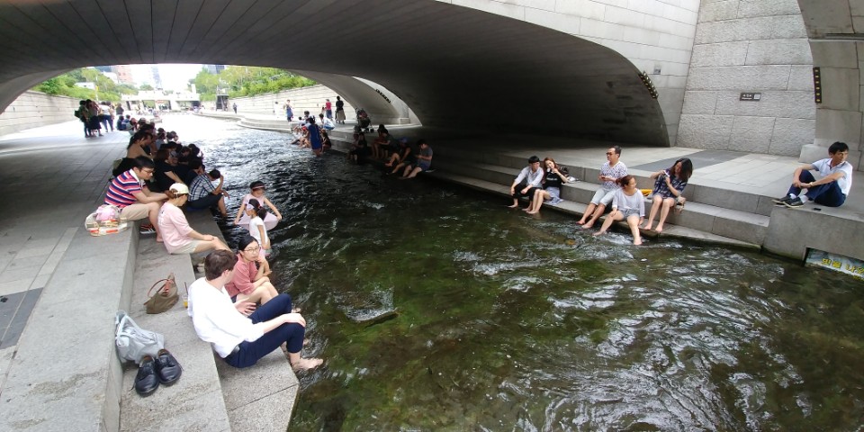 서울 청계천에서 시민들이 더위를 피해 다리 밑에 앉아있다. 