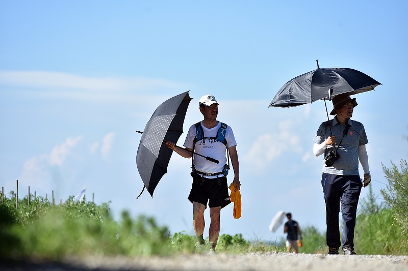 김형도 의장이 더위를 식히기 위해 우산을 들고 걷고 있다.