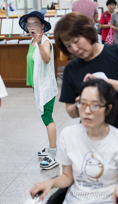  박근혜 전 대통령 지지자가 7일 오전 서울 서초구 서울중앙법원 5번 법정 입구 앞에서 이재용 삼성 부회장 공판을 들어가기 위해 줄을 서있는 삼성반도체 피해자 한혜경씨를 향해 손가락질을 하며 욕을 하고 있다.