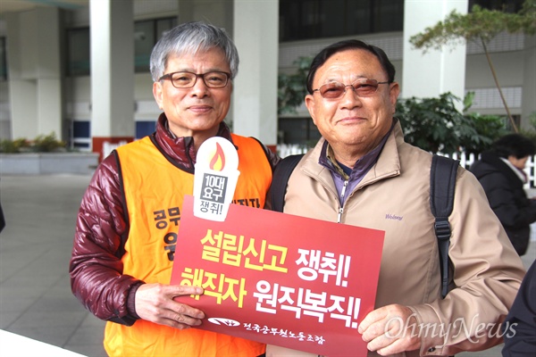 전국공무원노동조합은 해직 공무원 명예회복 등과 관련한 특별법안 제정을 요구하고 있다. 사진은 경남도청 공무원으로 있다가 해직되었던 김영길 전 전국공무원노동조합 위원장(왼쪽)이 '해직자 원직복직' 등의 구호가 적힌 손팻말을 들고 서 있는 모습.