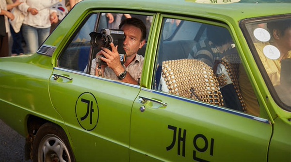 촬영중인 기자 피터 1980년 5월. 일본주재원으로 있던 독일방송국 소속 기자 피터는 광주에서 무슨 일이 벌어지고 있음을 직감하고 광주로  떠난다. 만섭의 택시를 타고 본 그의 카메라 렌즈에 광주의 참혹한 현장이 담겨진다. 