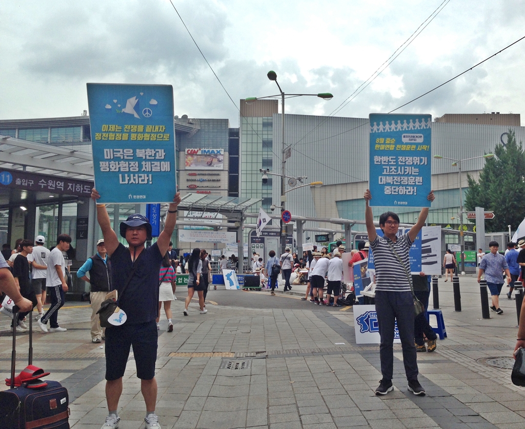 한반도 디톡스에 참가한 시민이 평화협정체결과 대북전쟁훈련중단을 요구하는 피켓을 높이 들고 있다.