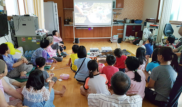 충남 예산군 광시면 은사리 마을회관에서 주민들과 도시소비자들이 영화를 관람하고 있다. 