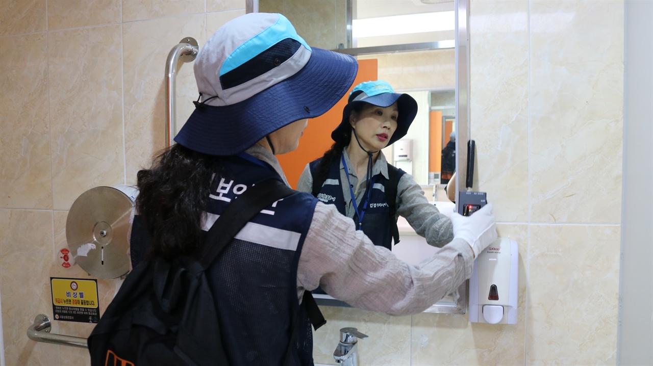 송파구 여성안심보안관이 화장실의 몰래카메라 설치를 확인하고 있다.