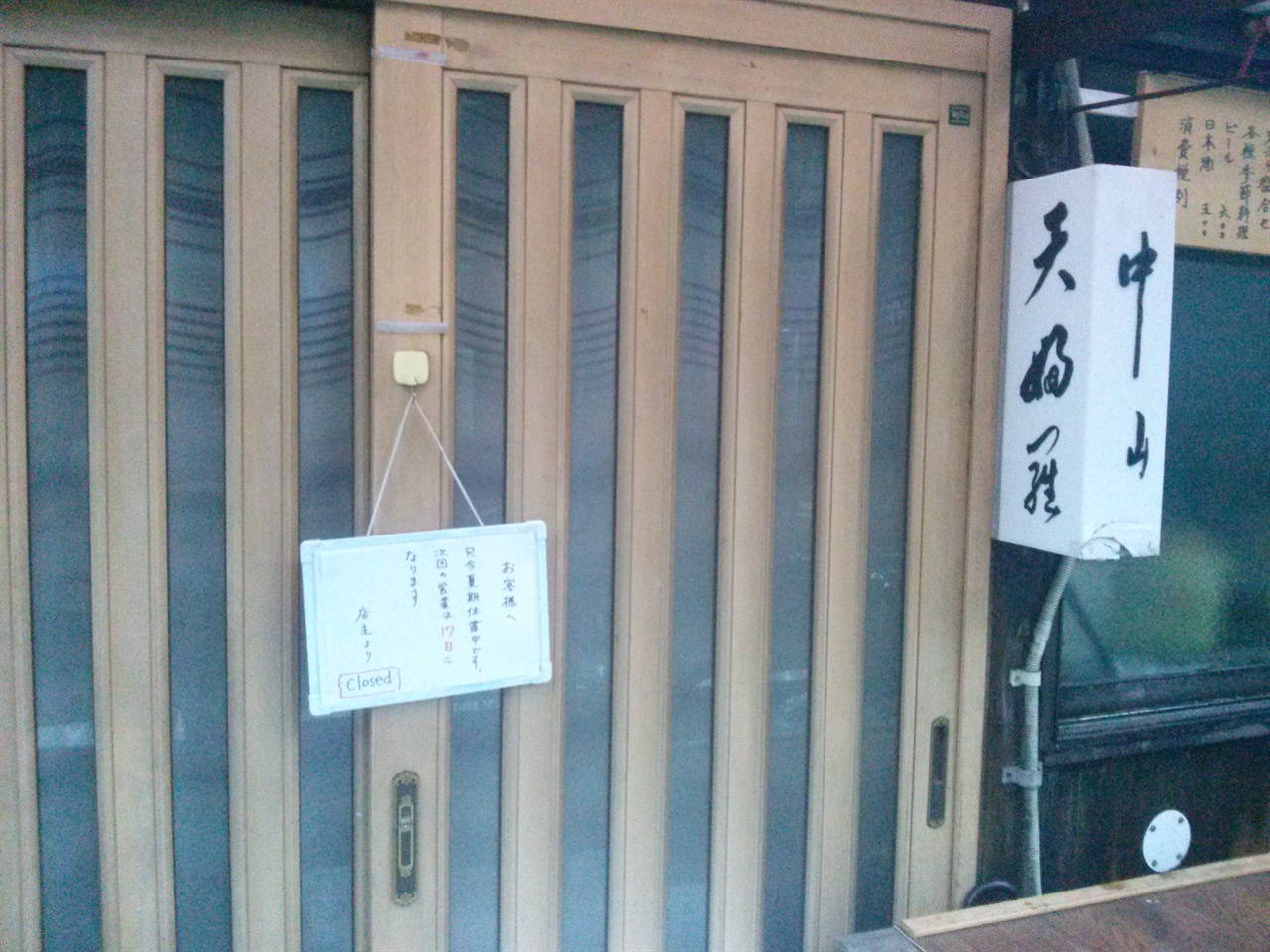 굳게 닫힌 텐푸라 나카야마의 문. 휴가 간다는 안내말이 외로이 걸려있다.