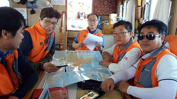 코리아나호에 탑승한  이사부항로탐사대원들에게 자신이 제작한 독도지도를 설명하는 안동립 대표(왼쪽에서 두번째)
