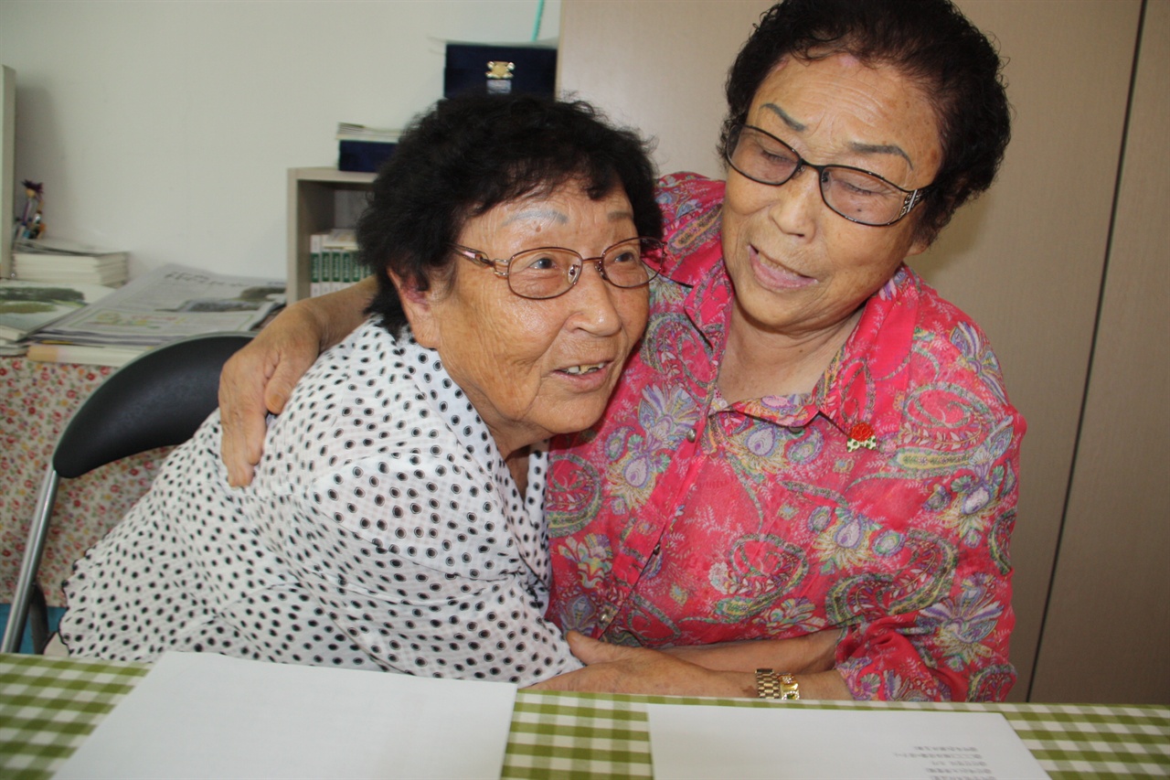 광복 72년 만에 만난 정신영할머니와 양금덕할머니가 기쁨에 겨워 서로를 끌어안고 환하게 웃고 있다. 