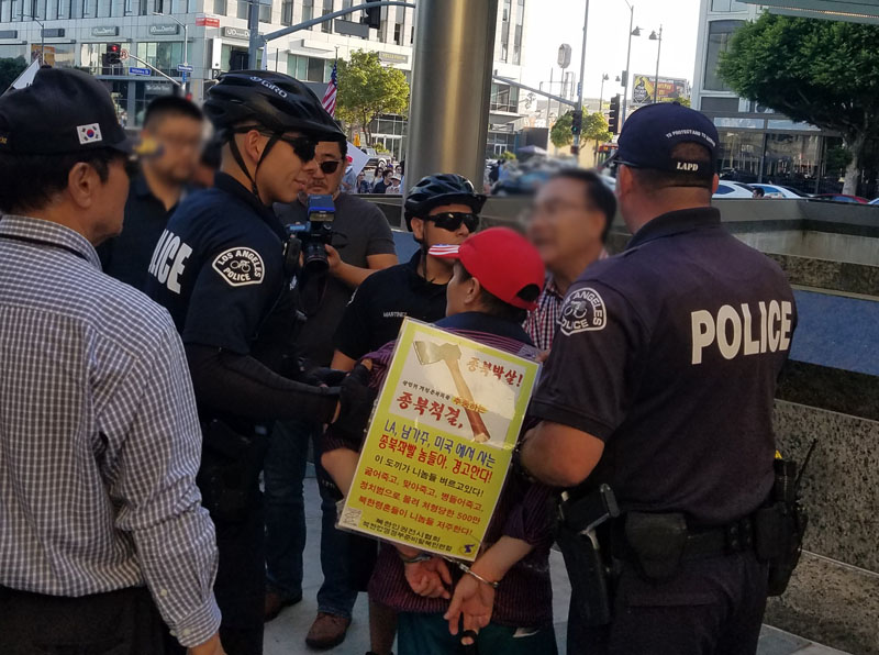 LA 평화집회장에 난입하여 폭력을 행사한 보수단체 회원이 경찰에 연행되고 있다.