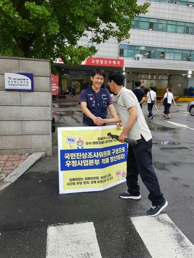 지난 17일, 전국집배노조 소속 집배원이 고양일산우체국 앞에서 1인시위를 하고 있는 모습. 이날은 문재인 대통령 취임 기념우표 판매 첫날이었다. 우표를 사러 우체국 앞에 줄을 서 있던 한 시민이 집배노조 소속 집배원과 악수하고 있는 모습. 