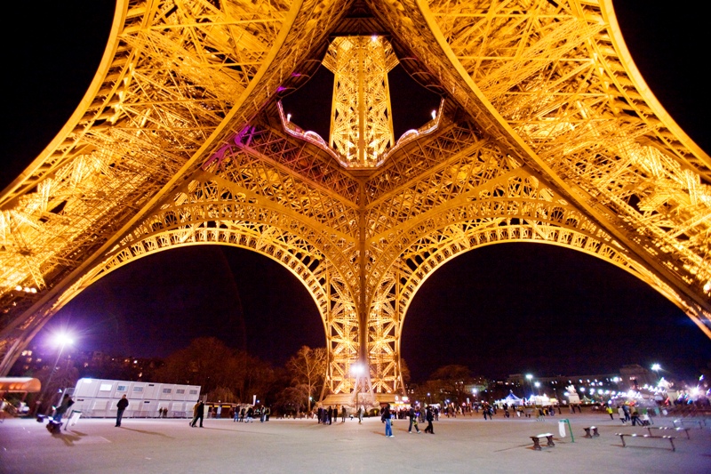 어둠이 내린 프랑스 파리. 에펠탑에 조명이 켜졌다. 그 아래를 지나는 사람들.