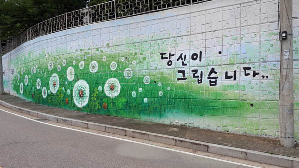 민들레 그림으로 재단장한 용미리 제1묘지 진입로.