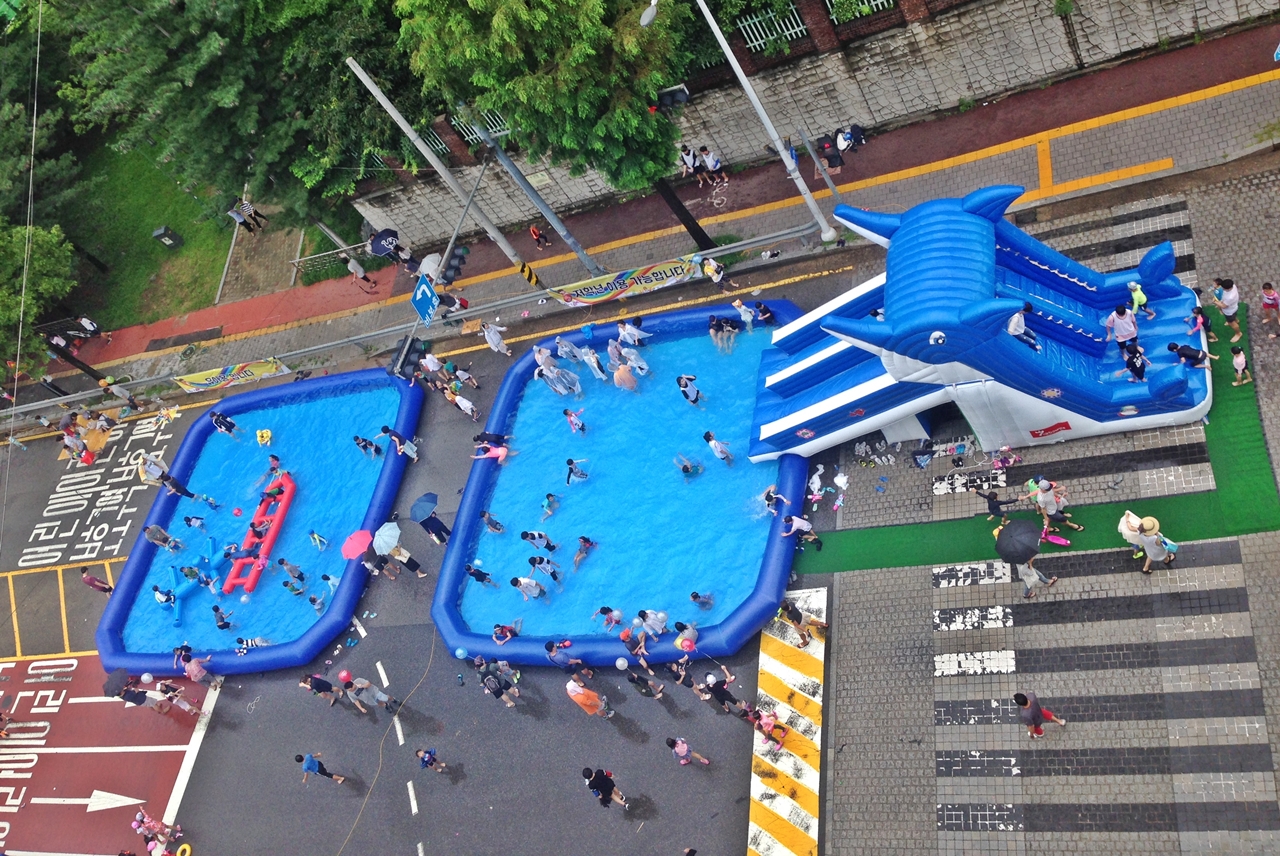 영통로 518 거리에 펼쳐진 간이 수영장에서 아이들이 맘껏 놀고 있다. 