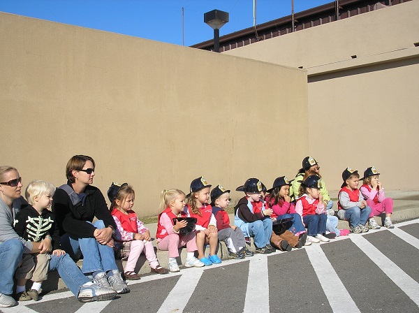 주한 미 공군 오산기지의 유치원 아이들과 학부모가 화재대피훈련에 참가해 소방대원들의 지시를 기다리고 있다. 