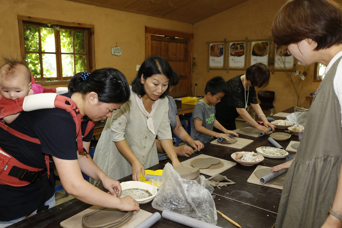 신효정 씨(왼쪽에서 두 번째)가 일반인을 대상으로 그릇을 만들어보는 도예체험 프로그램을 진행하고 있다. 