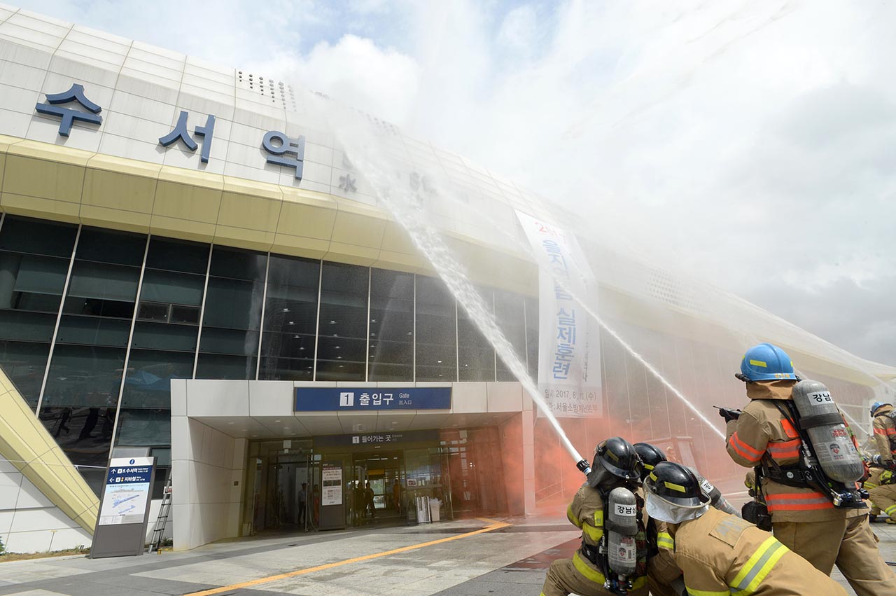 23일 오후 서울 강남구에 위치한 수서고속철도 SRT역에서 적의 장사정포격에 의해 발생한 대형건물 화재진압 및 인명 구조훈련이 실시됐다. 소방대원들이 화재가 발생한 건물를 향해 물을 뿌리며 화재를 진압하고 있다.