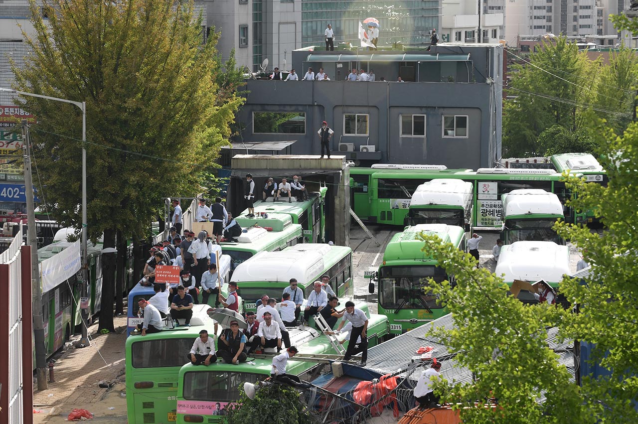 23일 오후 서울 송파구 거여동 송파상운 차고지에서 거여 2-2 주택재개발정비사업을 둘러싸고 차고지를 강제철거하려는 재개발조합측 철거용역에 맞서 송파상운 운전사들이 철거에 반대하며 버스위에 올라가 농성을 벌이고 있다.