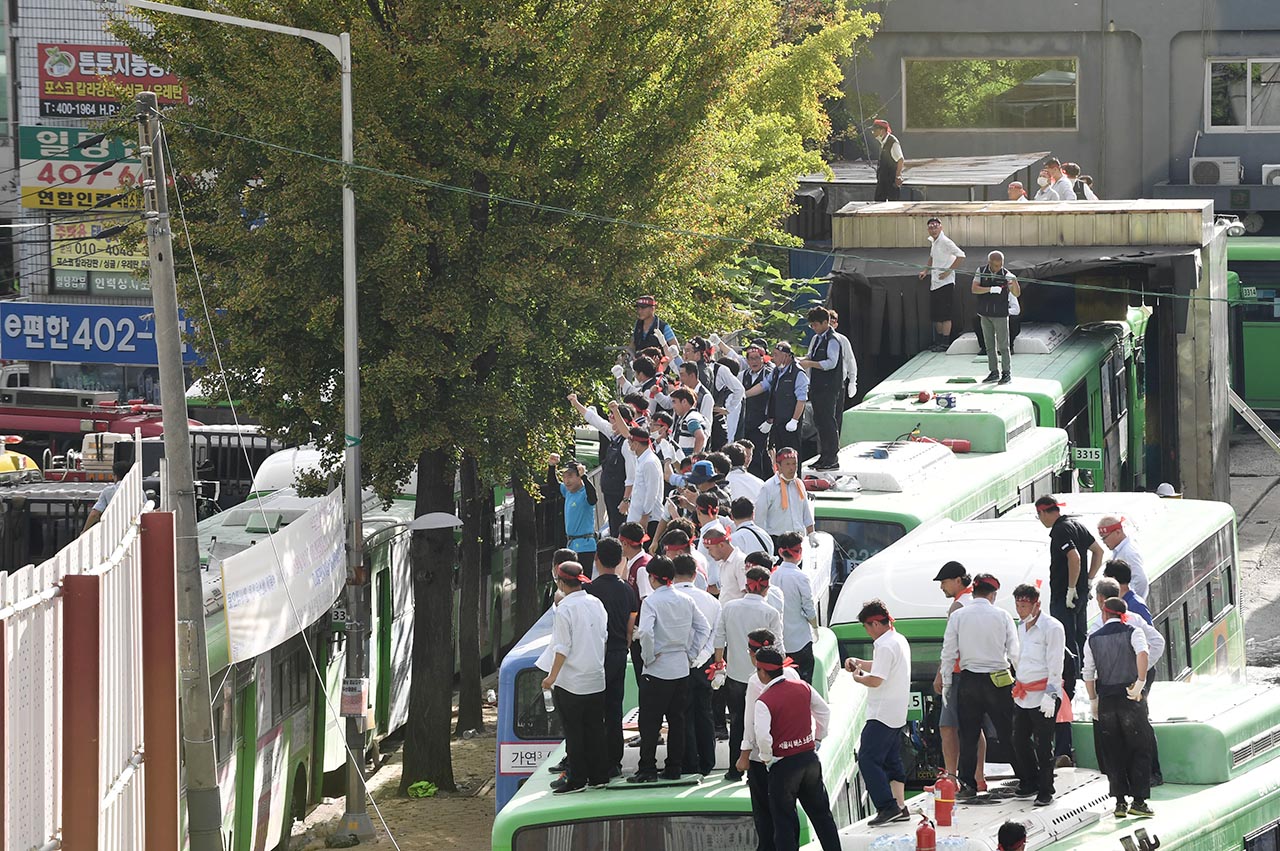 23일 오후 서울 송파구 거여동 송파상운 차고지에서 거여 2-2 주택재개발정비사업을 둘러싸고 차고지를 강제철거하려는 재개발조합측 철거용역에 맞서 송파상운 운전사들이 철거에 반대하며 버스위에 올라가 농성을 벌이고 있다.