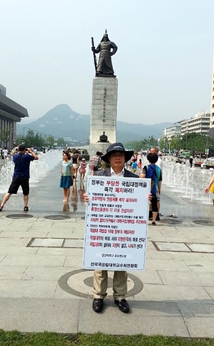광화문 이순신 동상 앞에서 피켓시위 하는 곽병선 교수(2014년 7월)
