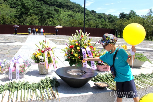 고 노무현 대통령 탄생 71주년을 맞아 김해 봉하마을 묘역에 꽃이 놓여 있고, 시민들이 참배하고 있다.