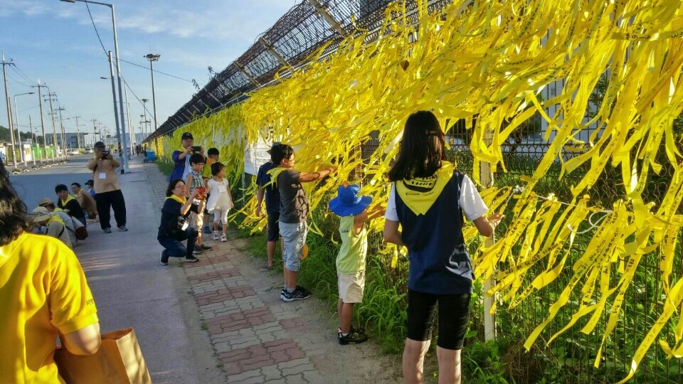 수원에서 열리는 촛불집회에서 보내온 노란 리본들을 이 날 함께 한 아이들이 목포신항 앞 철조망에 묶어주었다. 